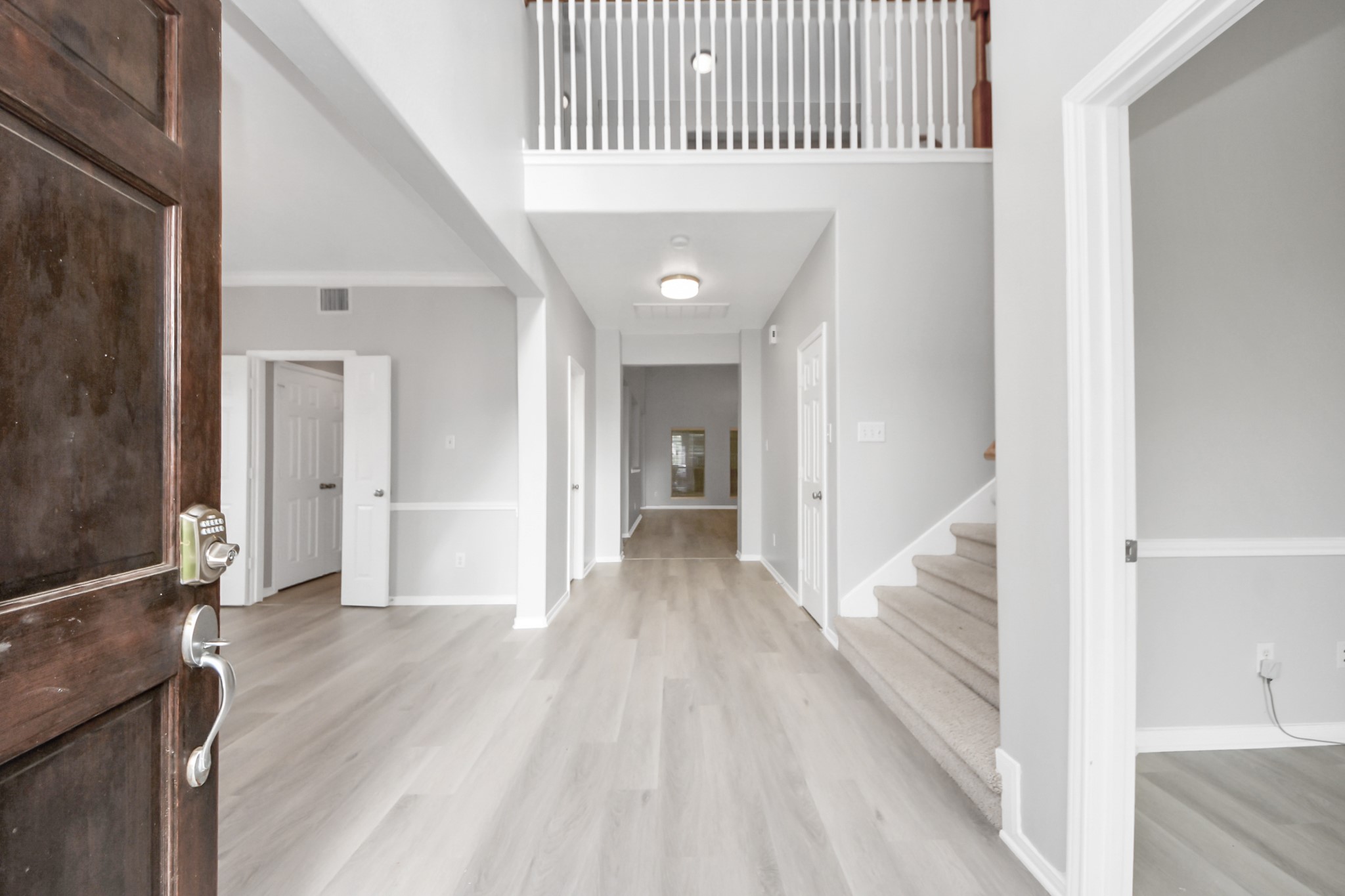 6803 Chapelfield Lane Houston, TX 77049 - Photo 11 of 50 a view of a hallway with wooden floor and staircase