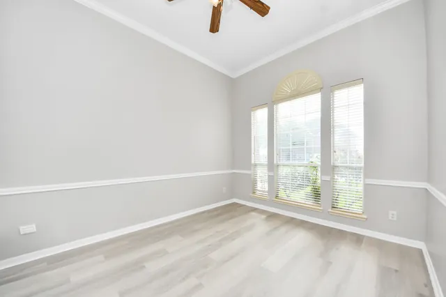 a view of an empty room with chandelier fan and fire place