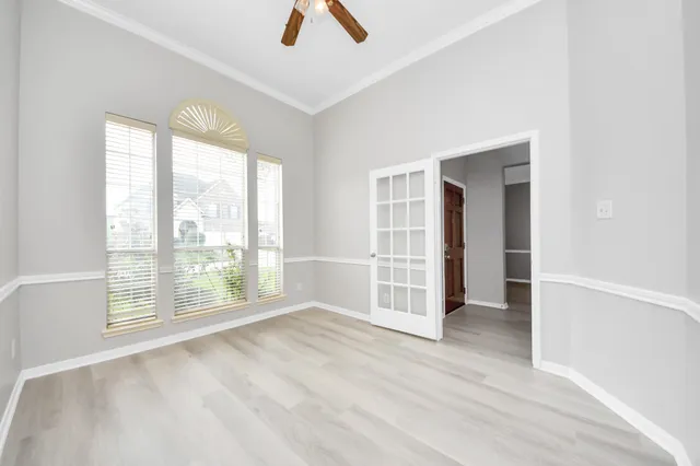 a large white kitchen with stainless steel appliances granite countertop a sink dishwasher a stove and white cabinets with wooden floor