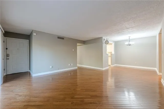 a view of a dining room with furniture a chandelier and wooden floor