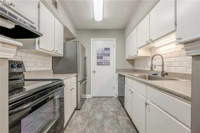 a kitchen with stainless steel appliances and cabinets