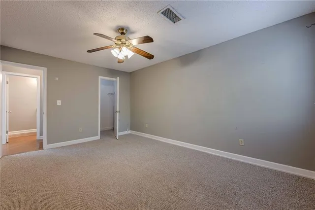 an empty room with a window and a fan