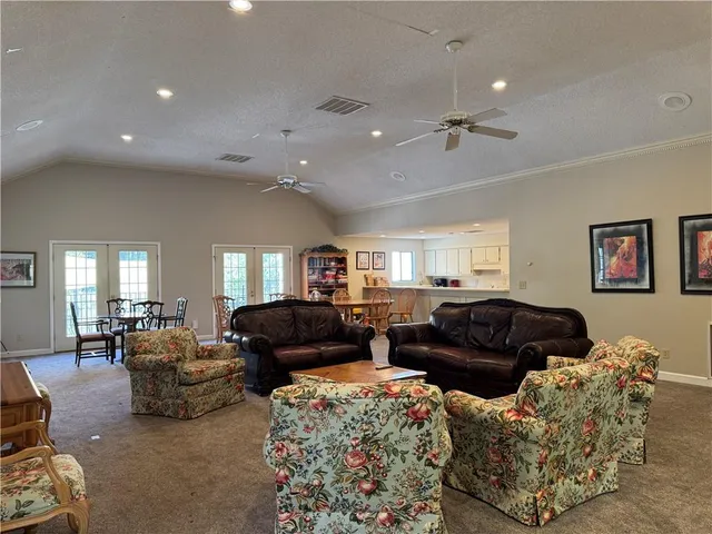 a sign of golf club on a wall under a tree