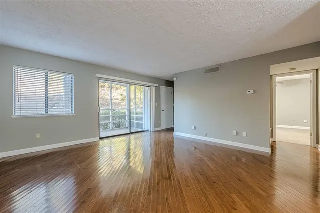 a view of a hallway with wooden floor and a chandelier