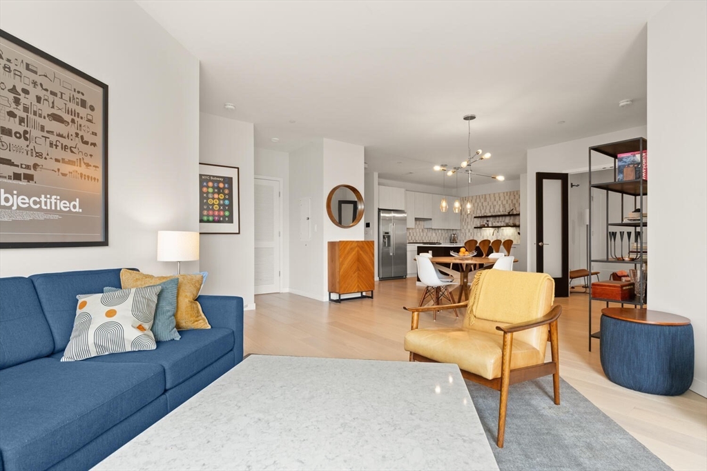 45 West 3rd Street, Unit 512 Boston, MA 02127 - Photo 5 of 40 a living room with furniture kitchen view and a chandelier