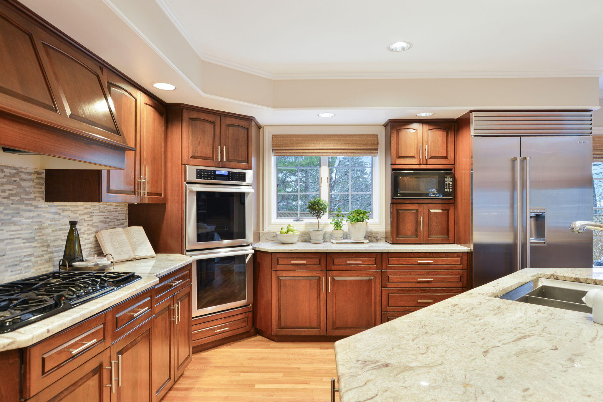 20 Stanley Place Hyannis, MA 02601 - Photo 14 of 37 a kitchen with stainless steel appliances granite countertop a stove top oven a sink dishwasher a dining table and chairs with wooden floor