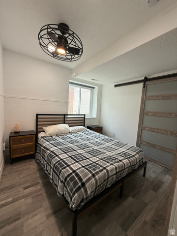 965 North 800 East Springville, UT 84663 - Photo 33 of 46 Bedroom featuring a barn door, dark wood finished floors, and a textured ceiling