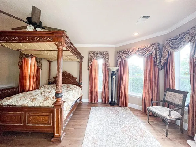 a bed sitting in a spacious bedroom next to a window