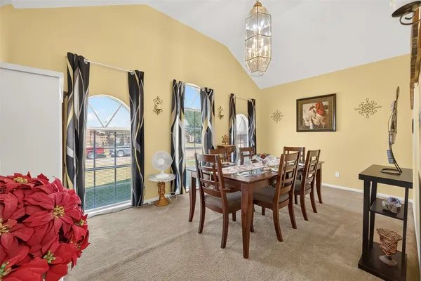 a view of a dining room with furniture and a chandelier
