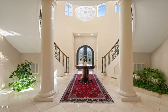 a living room with furniture a rug and a floor to ceiling window