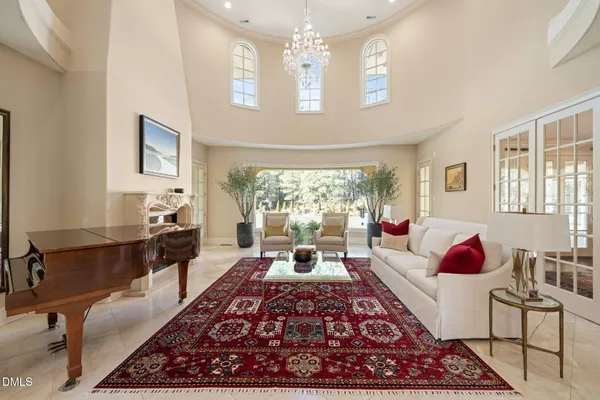 a living room with furniture a rug and a floor to ceiling window