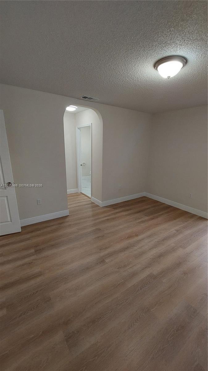 7083 Southwest 158th Court Miami, FL 33193 - Photo 14 of 22 an empty room with wooden floor and windows