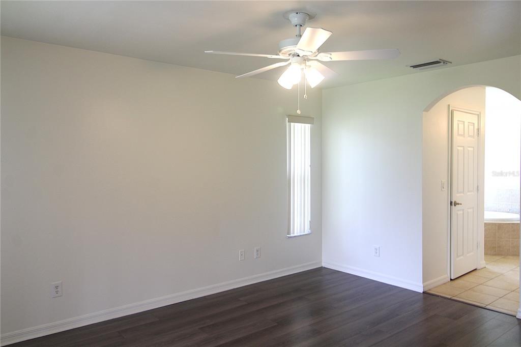 1489 Exchange Avenue North Port, FL 34288 - Photo 11 of 25 an empty room with wooden floor fan and window