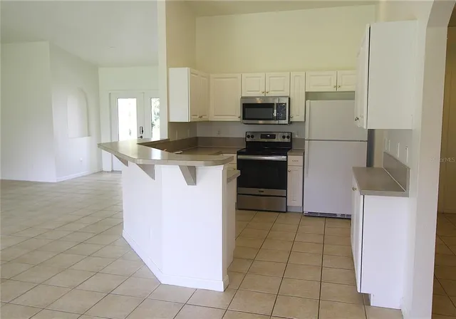 a kitchen with stainless steel appliances granite countertop a stove a refrigerator and a sink