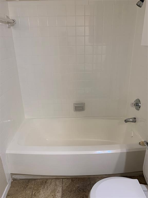 12482 Abrams Road, Unit 1303 Dallas, TX 75243 - Photo 12 of 30 Bathtub with white tile surround, chrome fixtures, and integrated soap dish