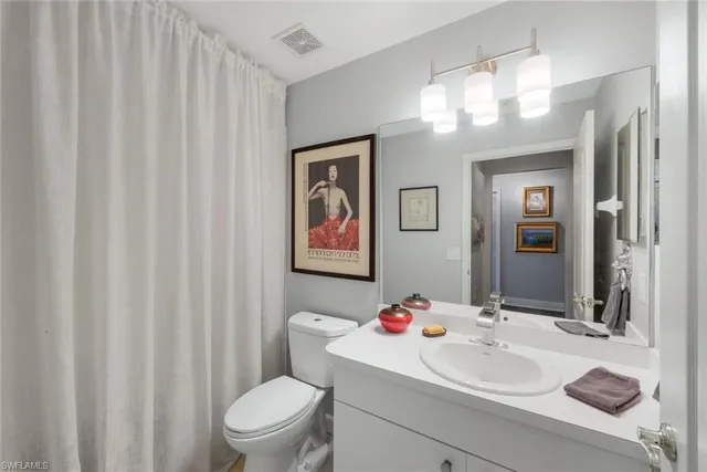 a bathroom with a sink vanity mirror and toilet