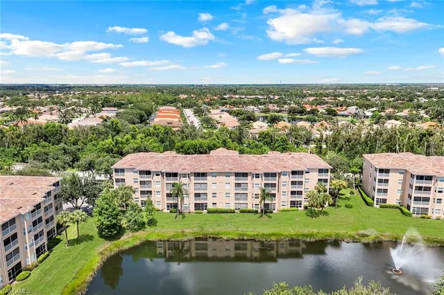 an aerial view of residential houses with outdoor space and lake view