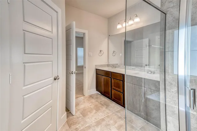 a bathroom with a shower sink and mirror