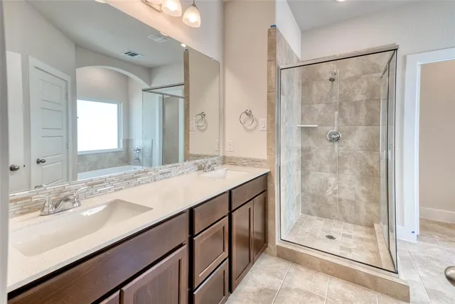a bathroom with a shower sink and mirror