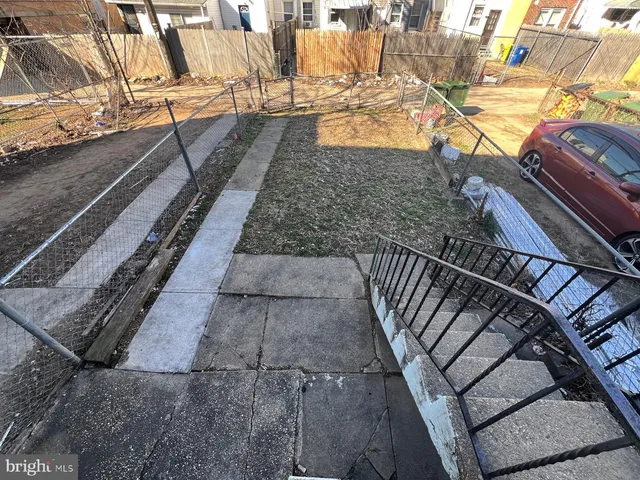 a view of a backyard with wooden fence