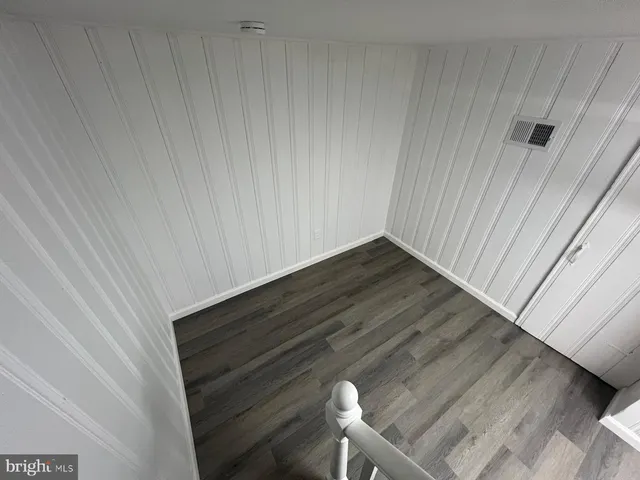 a view of an empty room with wooden floor