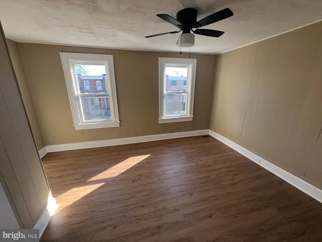 a view of empty room with wooden floor