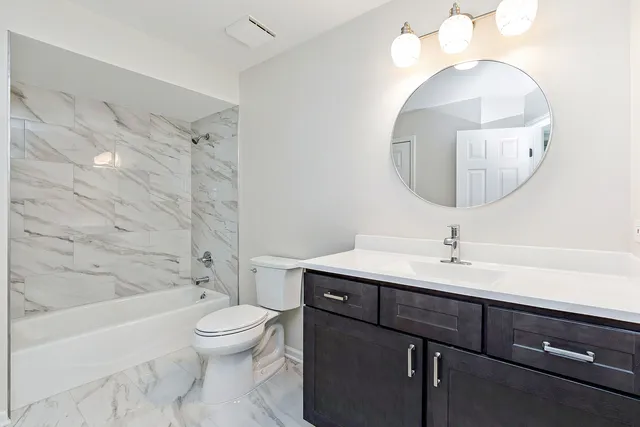 a bathroom with a toilet a sink and mirror