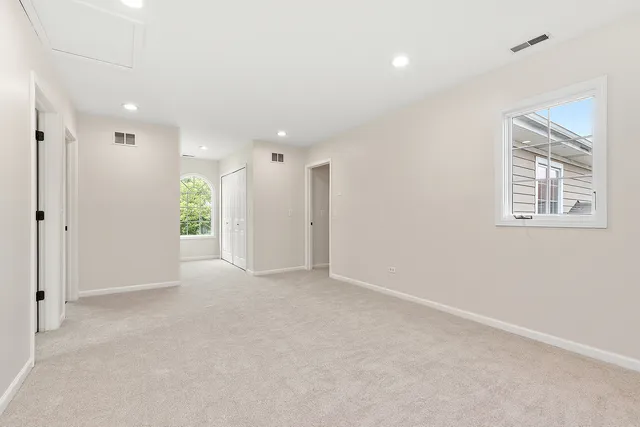 an empty room with windows and closet