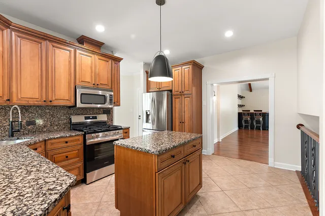a kitchen with stainless steel appliances granite countertop a stove oven and a refrigerator