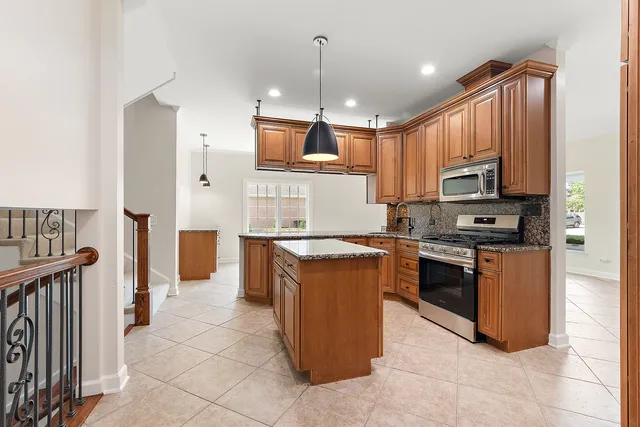 a kitchen with stainless steel appliances granite countertop a stove top oven a sink dishwasher and a refrigerator