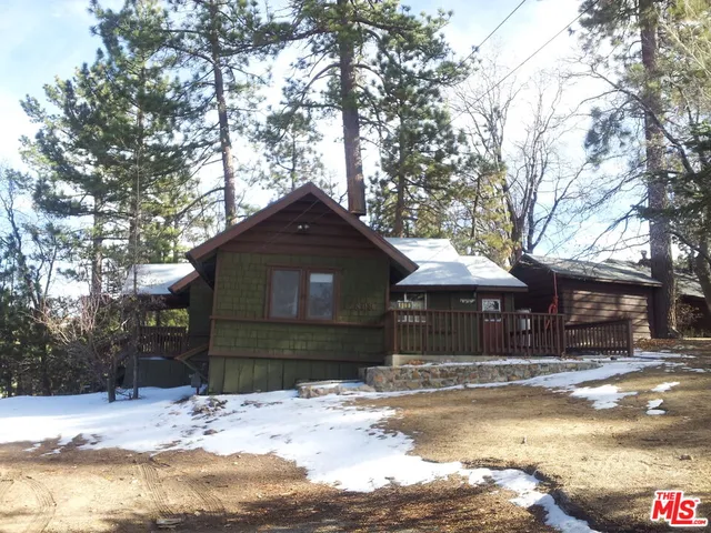 a front view of a house with a yard covered in snow