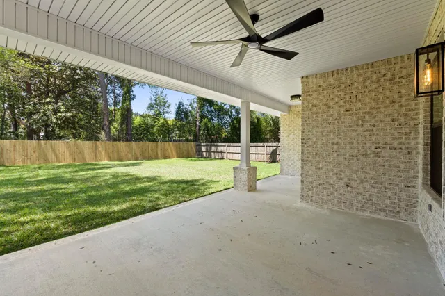 a view of an empty room with wooden floor and windows