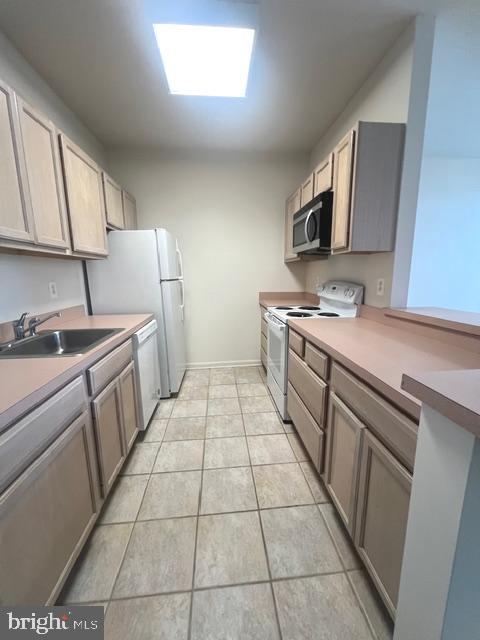 9000 Bay Avenue, Unit 106 North Beach, MD 20714 - Photo 6 of 12 a kitchen with a sink a stove top oven and white cabinets