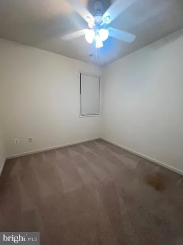 an empty room with a fan & a ceiling fan