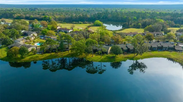 a view of swimming pool with lawn chairs under an umbrella