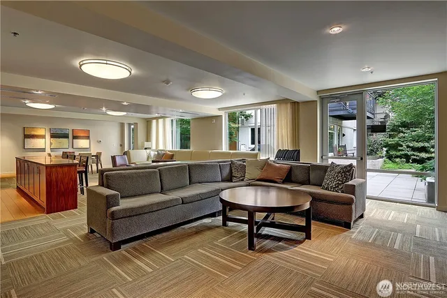 a living room with furniture a fireplace and a large window