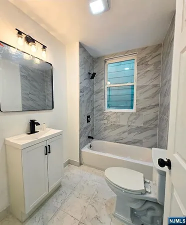 a bathroom with a toilet a sink a mirror a bathtub and shower