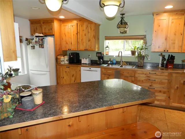 a kitchen with stainless steel appliances granite countertop a sink window and cabinets