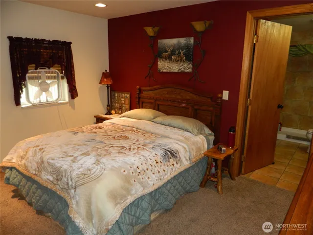 a bedroom with a bed and a painting on the wall