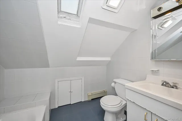 a white toilet sitting next to a bathroom sink and vanity
