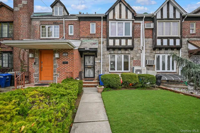 front view of a brick house with a yard