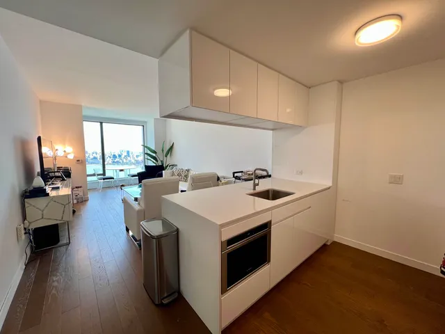 a kitchen with a stove and a wooden floor
