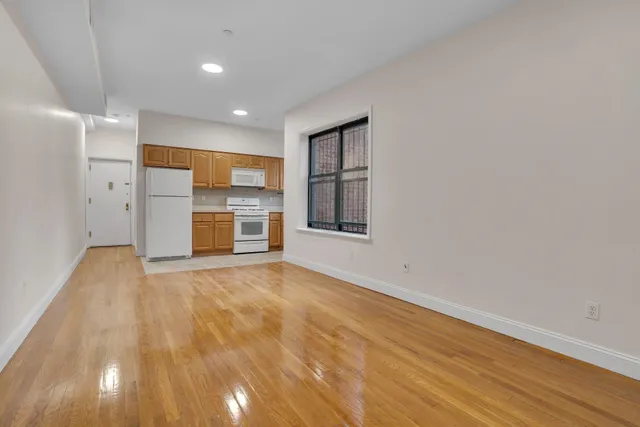wooden floor in an empty room with a kitchen