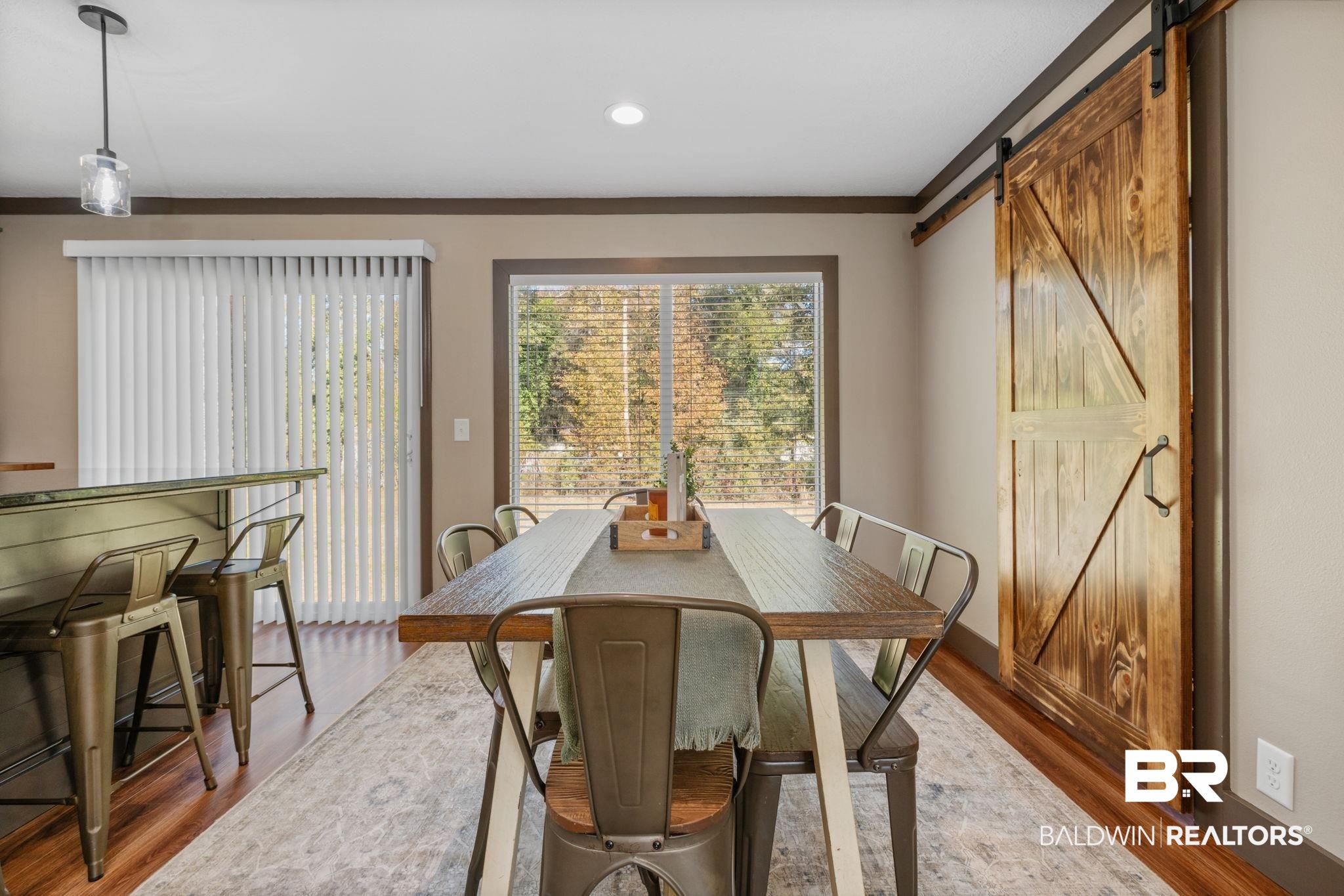 15080 Starlight Avenue Wilmer, AL 36587 - Photo 14 of 29 Dining room with a barn door and hardwood / wood-style floors