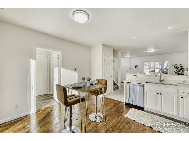 a living room with kitchen island furniture a wooden floor and a sink