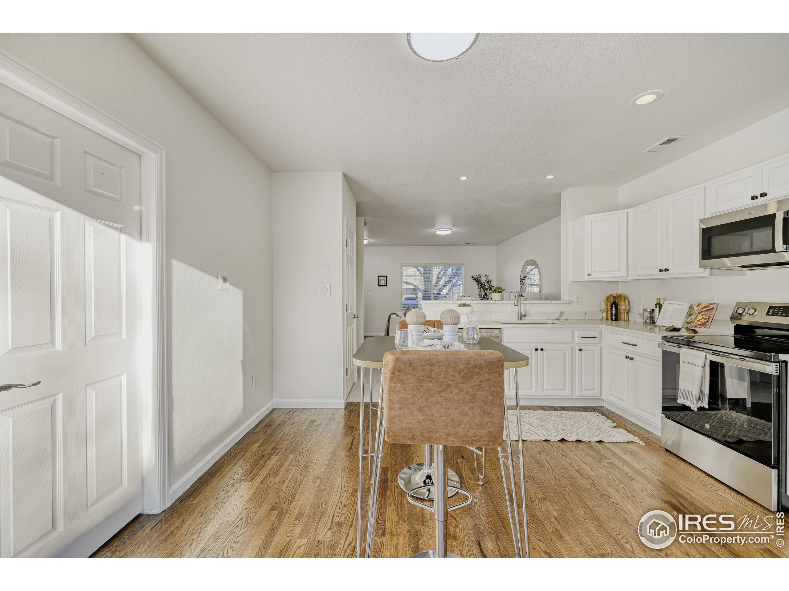 6130 Gorham Street Frederick, CO 80530 - Photo 14 of 48 a kitchen with stainless steel appliances granite countertop a refrigerator a stove top oven a sink and dishwasher with wooden floor