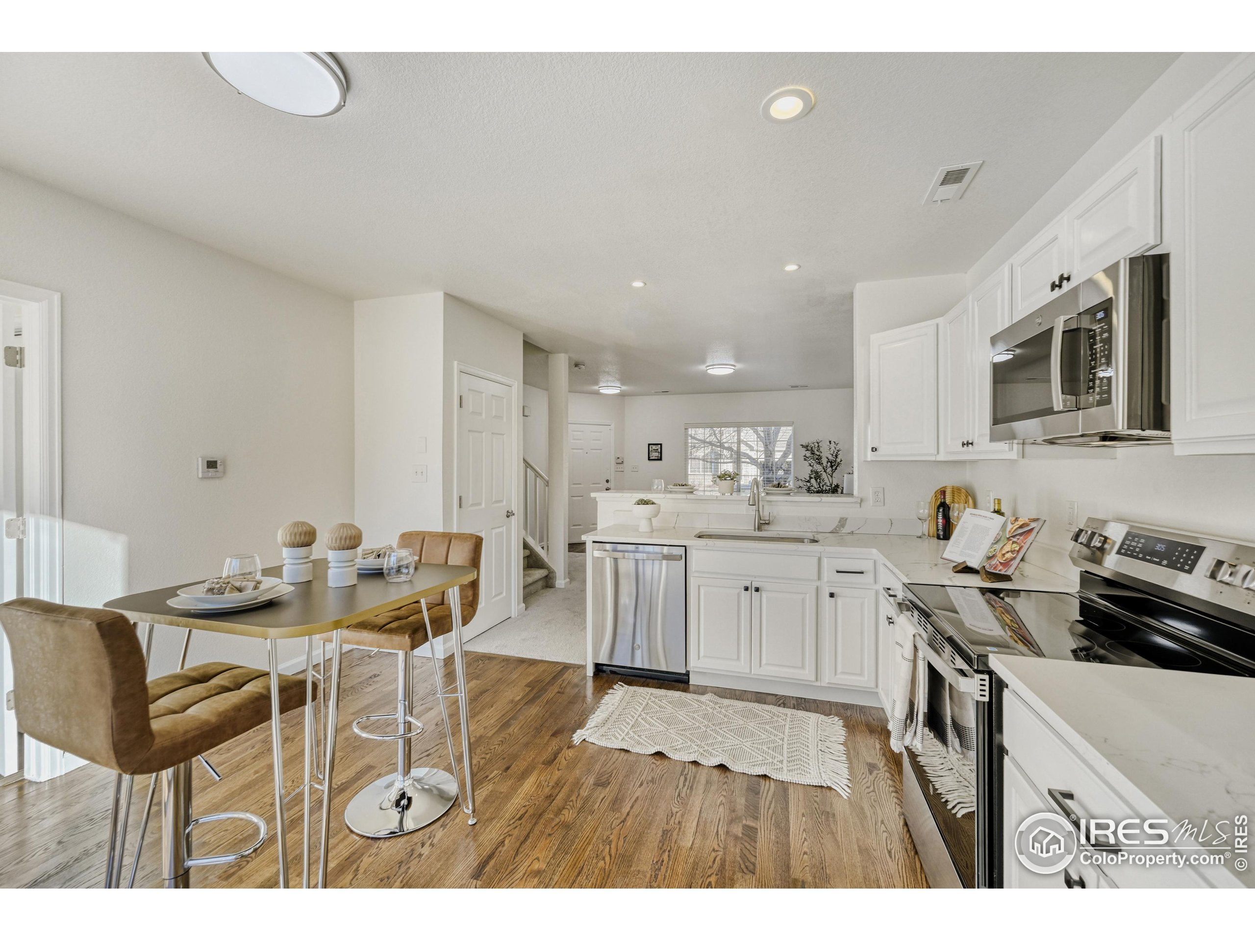 6130 Gorham Street Frederick, CO 80530 - Photo 15 of 48 a kitchen with a sink cabinets and wooden floor