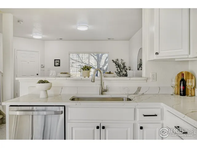 a kitchen with kitchen island granite countertop a sink and cabinets