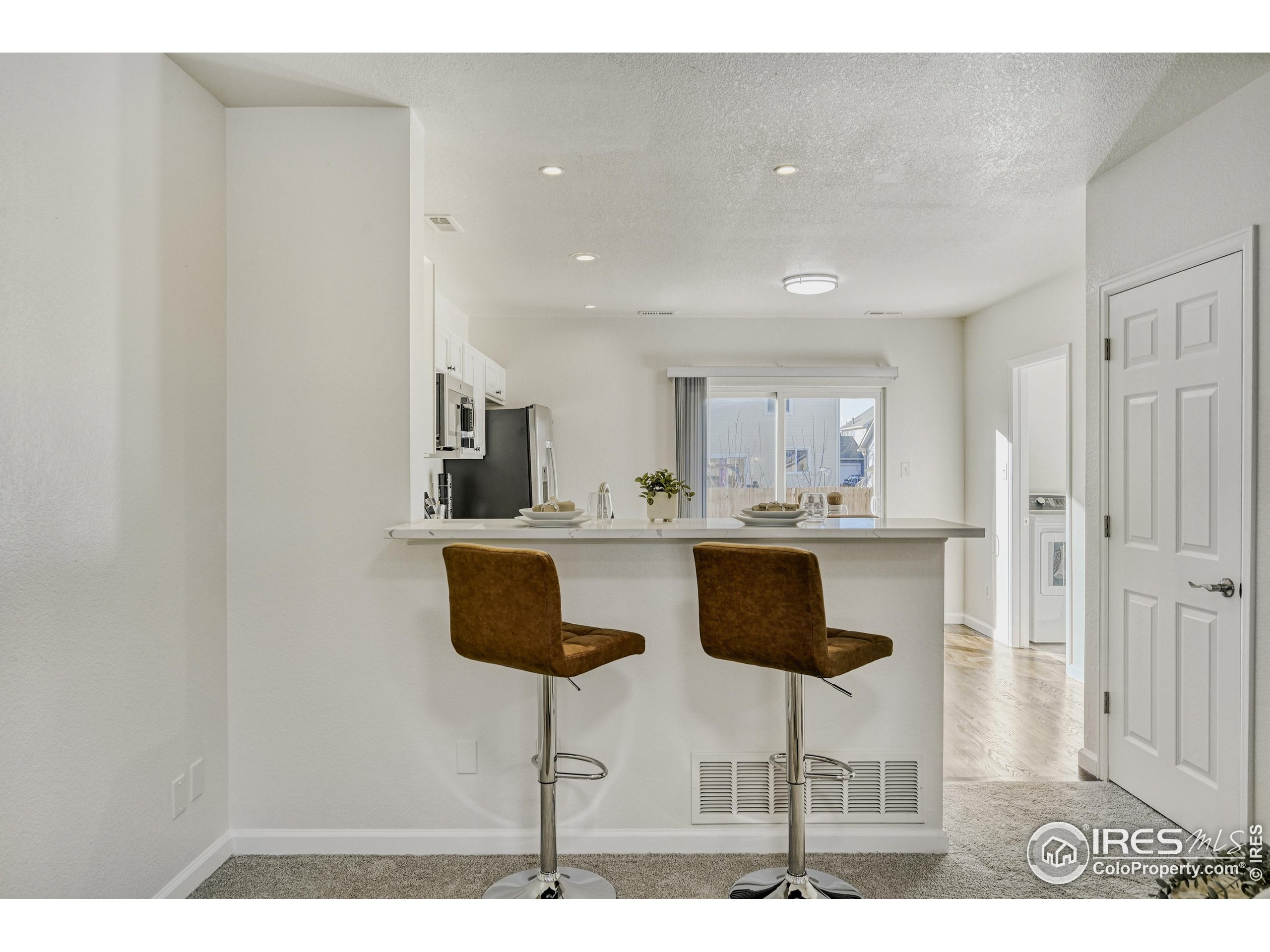 6130 Gorham Street Frederick, CO 80530 - Photo 20 of 48 a kitchen with stainless steel appliances kitchen island granite countertop a table and chairs