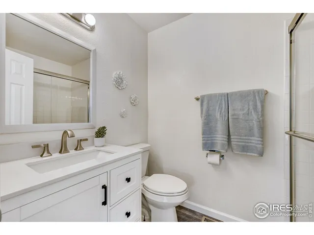 a bathroom with a toilet sink vanity and mirror